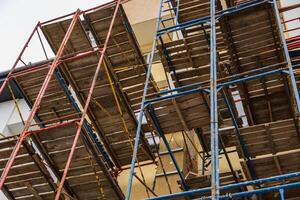 Workers use scaffolding to safely access upper levels of a multi-story construction project, enhancing efficiency in the construction process photo