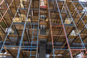 Workers utilize scaffolding to enhance safety and access during the construction of a multi-story building in a busy area photo