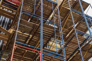 Workers assemble extensive scaffolding for the construction of a new building, highlighting industrial progress in urban development photo