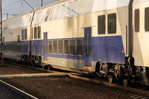 A sleek electric train approaches the platform at a bustling station, showcasing contemporary railway design and efficient transportation photo