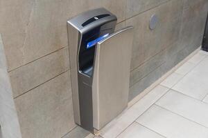 This modern hand dryer is installed in a bathroom, efficiently drying hands while enhancing hygiene and convenience for users photo