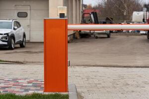 Closed security barrier at parking lot entrance restricts vehicle access and enhances safety for authorized entry only photo