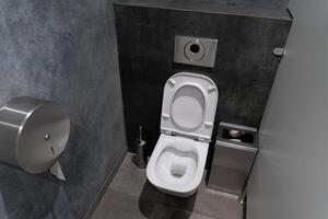 This restroom showcases a minimalist design with modern plumbing fixtures, emphasizing cleanliness and comfort for users in a public facility photo