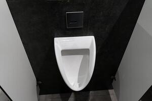 Minimalist urinal situated in a clean, modern restroom, highlighting hygiene and comfort in a public setting for male users photo