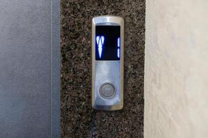 The control panel displays illuminated buttons for selecting floors in a contemporary apartment elevator setup photo