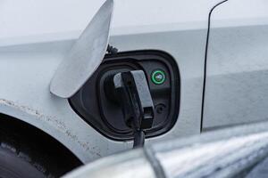 An electric vehicle is connected to a charging station, highlighting advancements in renewable energy and efficient transportation solutions photo
