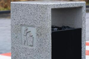 Solid gray container for rubbish and recycling stands empty, encouraging proper waste disposal in an urban environment photo