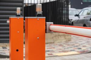 A closed security barrier stands at the entrance of a parking lot, regulating vehicle access while ensuring safety and control photo