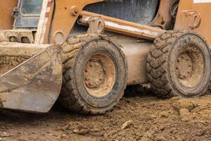 A backhoe is actively digging and moving dirt at a construction site, demonstrating the essential work of the construction industry photo
