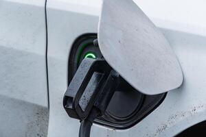 An electric vehicle connects to a charging station, highlighting advancements in transportation and renewable energy solutions for the future photo