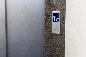 Control panel in a contemporary elevator displays the number two, indicating the second floor in a multi-story apartment setting photo