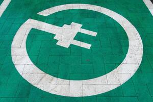A charging station marked on the ground emphasizes modern electric vehicle technology and sustainable energy practices in urban areas photo