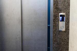 Steel elevator control panel showcases illuminated buttons indicating floor numbers for easy navigation within a building photo