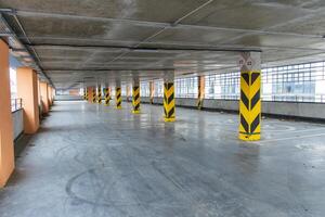 Empty parking garage with yellow and black pillars in a modern urban setting, showcasing clean lines and contemporary design elements photo