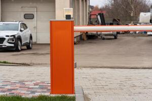 An automatic barrier gate stands closed at the entrance to a parking lot, ensuring secure access control and safety for vehicles photo