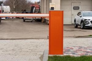 An automatic gate stands closed at the entrance of a parking lot, providing secure access control and enhancing safety for vehicles photo
