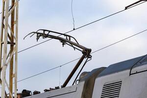 The overhead conductor of a modern electric train stretches above the railway, ready for transportation operations at the station photo