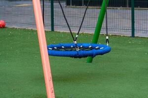 Children experience pure joy as they swing freely on a colorful play unit in a vibrant public park during a sunny day photo