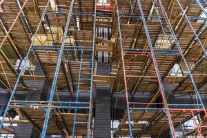 Workers navigate a complex scaffolding structure at a construction site, emphasizing safety and efficient development practices photo