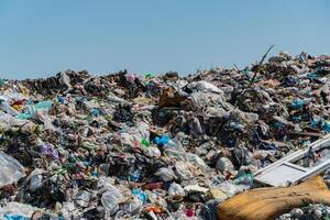 Piles of garbage and plastic debris cover the landfill, emphasizing ongoing waste management issues and the impact on the environment photo