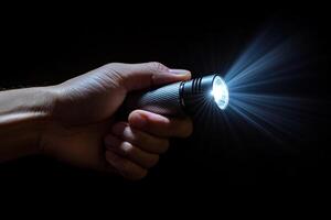 close-up of a hand gripping a glowing flashlight in a dark setting, symbolizing themes of exploration, mystery and the search for truth photo