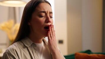 Caucasian tired woman yawning girl female sleepy at home living room low energy insomnia chronic exhausted health problem yawn indoors lazy boring apathy mood need napping sleeping feeling boredom video