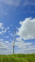 Breathtaking shots of a wind turbine against a vibrant sky with clouds, showcasing renewable energy in a picturesque natural setting video