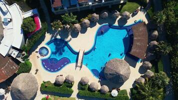 Tourist swimming pool located at an all-inclusive hotel. Aerial top view video