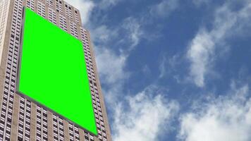 Chroma Key Green screen vertical billboard on modern building for advertising with bright sky and moving clouds backgrounds video