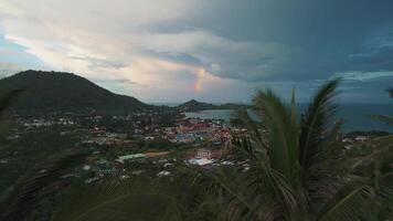 Dynamic cinematic shot of rainbow in the sky over tropical island sea and palm trees, cinematic fast drone flight over palm trees, shows time after tropical thunderstorm and rainbow in the sky video