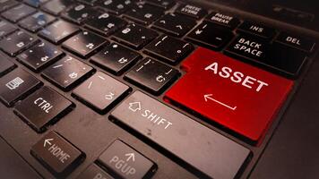 A red asset button on a laptop keyboard photo