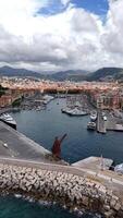 Aerial view of the port in Nice, France. Boats, sailboats, speedboats and yachts moored in the port, drone view. Vertical video