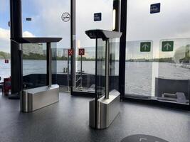 Modern turnstiles and glass exit gates inside river transport terminal with panoramic view of the water. Smart public transport infrastructure for urban mobility and seamless boarding photo