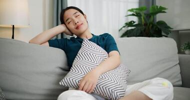 entspannt Frau ist Sitzung auf ein Sofa, genießen das Frieden von Verstand und scheint zu Sein Denken Über etwas im ein positiv Stimmung beim heim. video