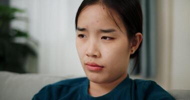 Woman sitting alone on the sofa thinking about life problems with a stressed expression. video
