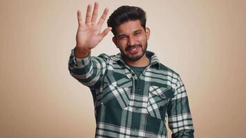 Come here, join us. Welcome. Hindu bearded man showing inviting gesture with hands, ask to join, beckoning to coming, gesturing hello, goodbye. Handsome indian guy isolated on beige studio background video
