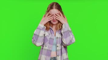 Dont want to look at this, awful. Afraid shocked caucasian woman closing eyes with hand showing stop gesture, confused shy scared reject to watch. Redhead girl isolated on green chroma key background video