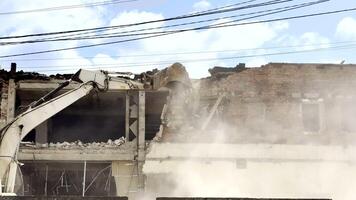 Excavator tears down a war-damaged building in Ukraine, clearing ruins after conflict. Scene reflects destruction, cleanup, and the beginning of postwar recovery and reconstruction efforts. video