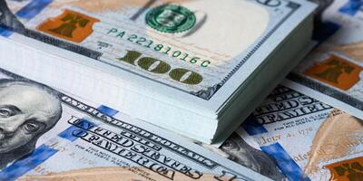 A bundle and a roll of dollars on bills of one hundred dollars. photo