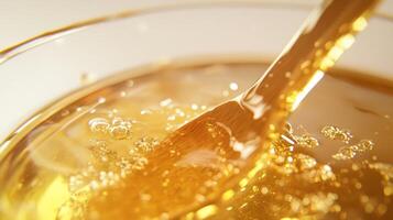 Honey Being Stirred in a Bowl with a Wooden Spoon photo