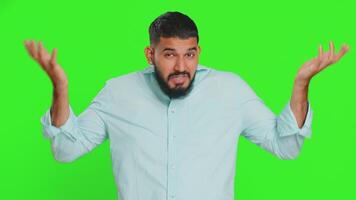 I dont know what to say. Confused Indian young man feeling embarrassed about ambiguous question, having doubts, no answer, idea, being clueless, uncertain. Guy isolated on green chroma key background video