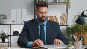 Caucasian businessman sitting at home office workplace desk closing laptop pc after finishing work. Bearded man freelancer working online remote job. E-learning, browsing internet on notebook computer video