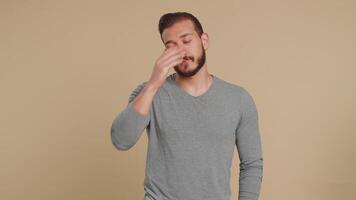 Lebanese young man tired bored indifferent expression, exhausted of tedious story, not interested in communication talk, displeasure, uninteresting. Middle eastern guy isolated on beige background video