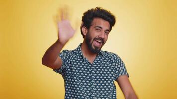Come here, join us. Welcome. Hindu bearded man showing inviting gesture with hands, ask to join, beckoning to coming, gesturing hello, goodbye. Handsome indian guy isolated on yellow studio background video