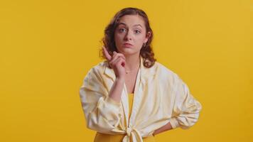 Quarrel. Displeased young woman gesturing hands with irritation and displeasure, blaming scolding for failure, asking why this happened. Brunette attractive girl isolated on yellow studio background video