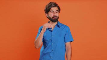 Tired exhausted young middle eastern man yawning sleepy inattentive feeling somnolent lazy bored gaping suffering from lack of sleep insomnia. Guy in shirt isolated on orange studio background indoors video