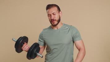 Like. Athlete sportive man raises thumbs up agrees with something or gives positive reply feedback recommends advertisement likes good. Middle eastern sportsman guy with dumbbell on beige background video
