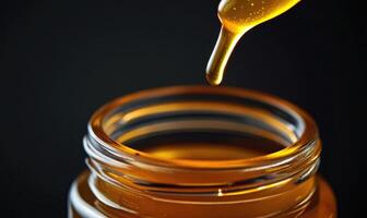 A bottle of honey is poured into a glass photo