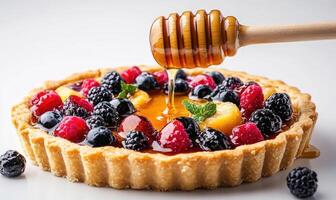 A dessert with a honey drizzle and berries on top photo