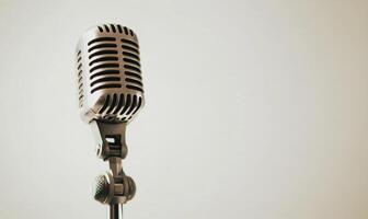A microphone is on a stand in front of a white background photo